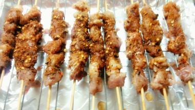 220度烤5分钟后取出，在羊肉串上撒下一些辣椒粉和孜然粉，继续220度烤10分钟