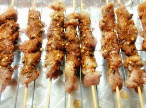220度烤5分钟后取出，在羊肉串上撒下一些辣椒粉和孜然粉，继续220度烤10分钟