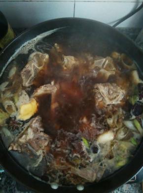 炒出香味加入开水淹没食材，放入香叶，草果和冰糖