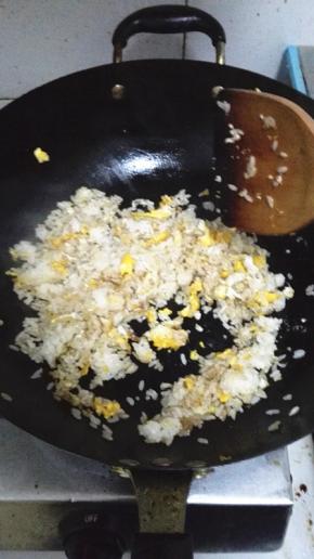将米饭压散之后加入生抽，与鸡蛋翻炒均匀