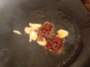 锅内放油烧热，加入姜蒜和豆瓣酱炒出香味