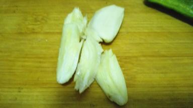 大蒜用刀背拍散，切成碎末