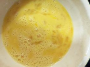 将鸡蛋打入碗中，加入牛奶和盐，朝一个方向搅拌均匀