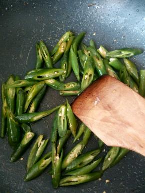 炒锅中倒少量油，热油下青尖椒快速翻炒，放盐给青尖椒调味，炒好后盛出备用