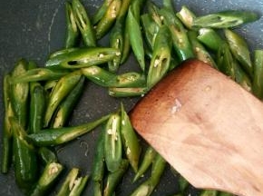 炒锅中倒少量油，热油下青尖椒快速翻炒，放盐给青尖椒调味，炒好后盛出备用