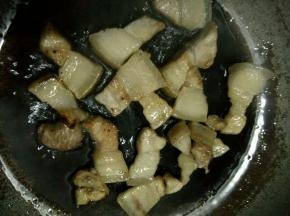 倒入少许油，小火将五花肉炒至金黄