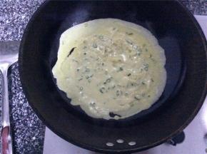 调成小火，把调好的面浆倒入锅中，颠动炒锅将面糊平均摊在锅中，使其受热均匀