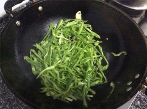 油锅加热，放蒜片爆香，加青椒丝大火爆炒