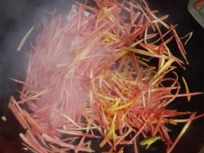 锅中放入少许油，油热之后放上姜末爆炒，倒入胡萝卜丝