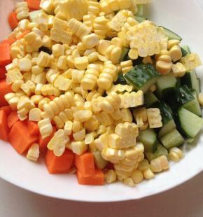 将胡萝卜和黄瓜切成丁，与玉米粒放入盘子中备用