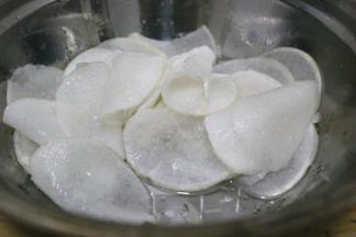 切好的萝卜片放入碗中，撒上半勺盐，搅拌均匀，静置30分钟