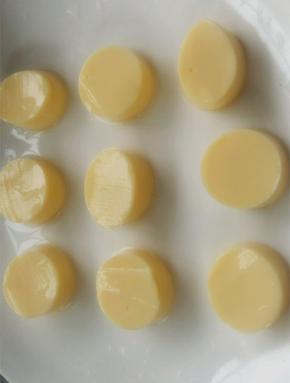 将日本豆腐从中间切开，用手拿着袋子底部，轻轻地将日本豆腐让在砧板上，切成相同的片状，摆在盘子备用