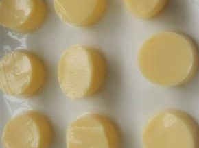 将日本豆腐从中间切开，用手拿着袋子底部，轻轻地将日本豆腐让在砧板上，切成相同的片状，摆在盘子备用