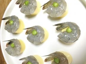 将腌好的虾仁放在豆腐上，中间用一颗豌豆点缀