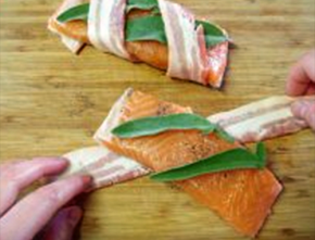 在每块三文鱼上放2片鼠尾草，将培根斜斜的缠绕包裹