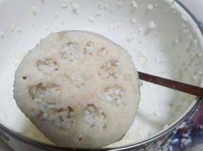 将切好的藕竖起来放，往莲藕的孔洞里填入糯米，用筷子慢慢地将糯米推入