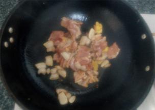 锅中倒入少量食用油，把肥肉片入锅煸干，而后放上腌好的瘦肉快速翻炒