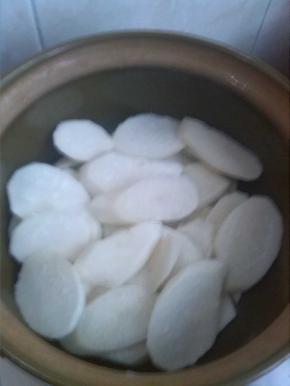 白萝卜去皮切成片，铺在锅底