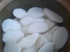 白萝卜去皮切成片，铺在锅底