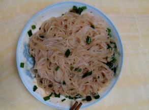 把冷却后的粉丝放入盘中，撒上葱花，加入适量的花椒油、酱油、盐和红油辣椒，搅拌均匀即可