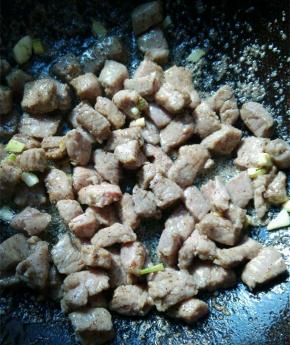 锅内放少许的油，油热放入腌好的牛肉粒，小火翻炒