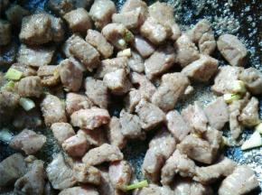 锅内放少许的油，油热放入腌好的牛肉粒，小火翻炒
