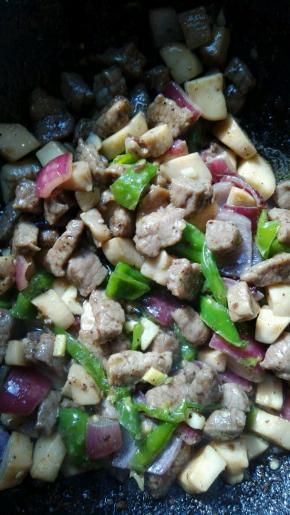 翻炒至牛肉微微变色，加入炒好的蔬菜丁，将牛肉炒熟