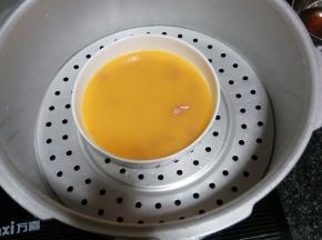 锅中加入适量清水，放上蒸盘，把火腿丁放在蛋液里面，加少许温水，蒸5-10分钟