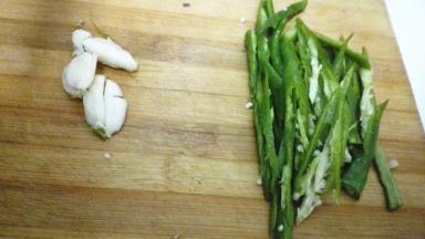 大蒜用刀背拍扁，青椒切成丝备用