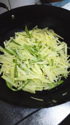 待土豆丝断生倒入青椒翻炒