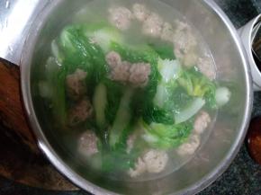 锅中加清水，水开后把丸子放入锅中煮，丸子煮熟后放上小白菜，加盐调味，煮好后出锅