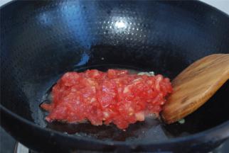 西红柿去皮切丁，放入锅中小火翻炒出汁