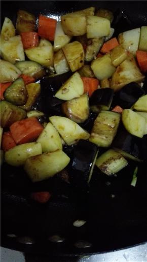 用剩下的油将茄子翻炒变软，同样捞出，炒锅内重新到少量的油，油热之后放入蒜末炒出香味儿，倒入土豆，茄子和胡萝卜。