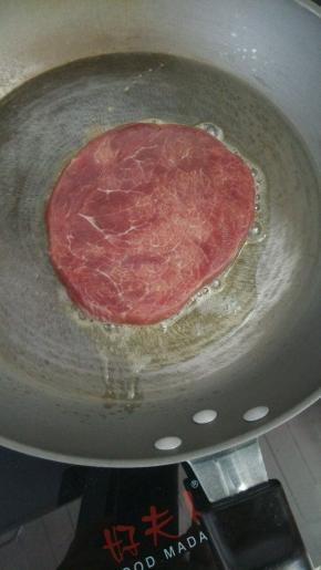 放入牛排，中火煎至双面金黄，每隔10秒翻一次面