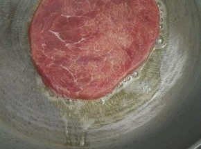 放入牛排，中火煎至双面金黄，每隔10秒翻一次面