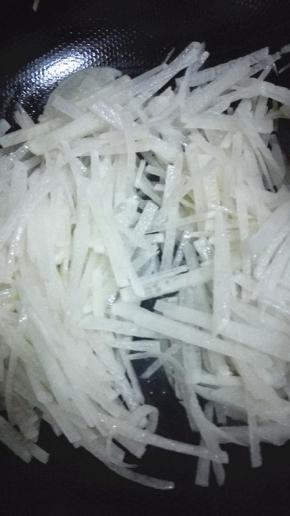 锅内放少许的油，油热之后放入萝卜丝翻炒出水分