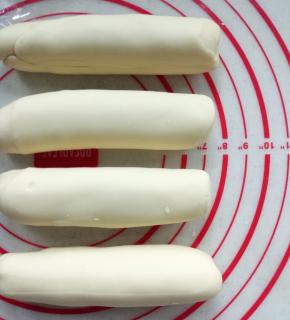 10分钟后，把面团分成4份，然后搓成20厘米长条，裹上保鲜膜继续松弛10分钟。烤箱预约200度