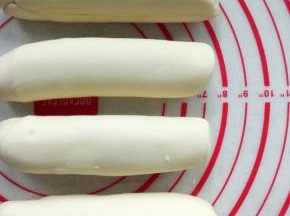 10分钟后，把面团分成4份，然后搓成20厘米长条，裹上保鲜膜继续松弛10分钟。烤箱预约200度