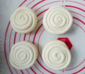 将擀平的长条面片对折，对折后，从顶端卷起，卷成一个圆筒，最后收尾压在卷的底端