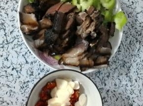 腊肉过水煮熟切片，青椒、小米辣切圈、大蒜切片备用