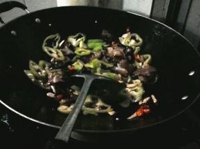 热锅倒油，油烧开后放小米辣和蒜瓣爆香，加腊肉炒出油，炒制2分钟后加青椒翻炒