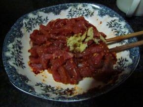 瘦肉洗干净切成丝，加入适量生粉、姜粒和豆瓣酱，腌制5-10分钟入味