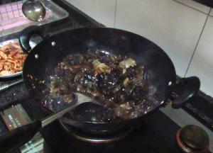 大火加热锅中剩余的油，将木耳沥干水分，放入锅中翻炒