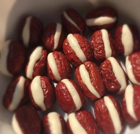 从和好的面团中捏出1块揉成条状塞入到红枣的口子中