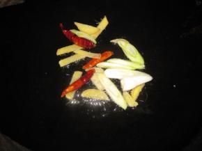锅中热油，转中小火把干辣椒、生姜、花椒、青椒放入锅中炒香