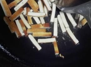 油锅烧热，放上姜蒜粒爆香，倒入豆腐干翻炒