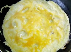 热锅温油，把鸡蛋液倒入，凝固成型后翻炒