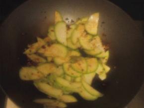 倒入小瓜翻炒，放上少许的酱油增色调味，翻炒均匀，炒熟出锅