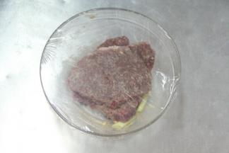 牛排放入碗中，双面均匀的涂抹上橄榄油，粗海盐和黑胡椒。盖上保鲜膜腌制30分钟以上