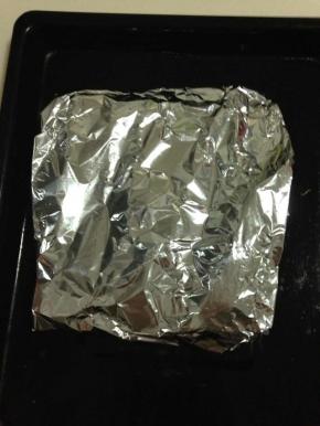 羊排放在锡纸上，撒上迷迭香，四周包裹严实放入烤盘中